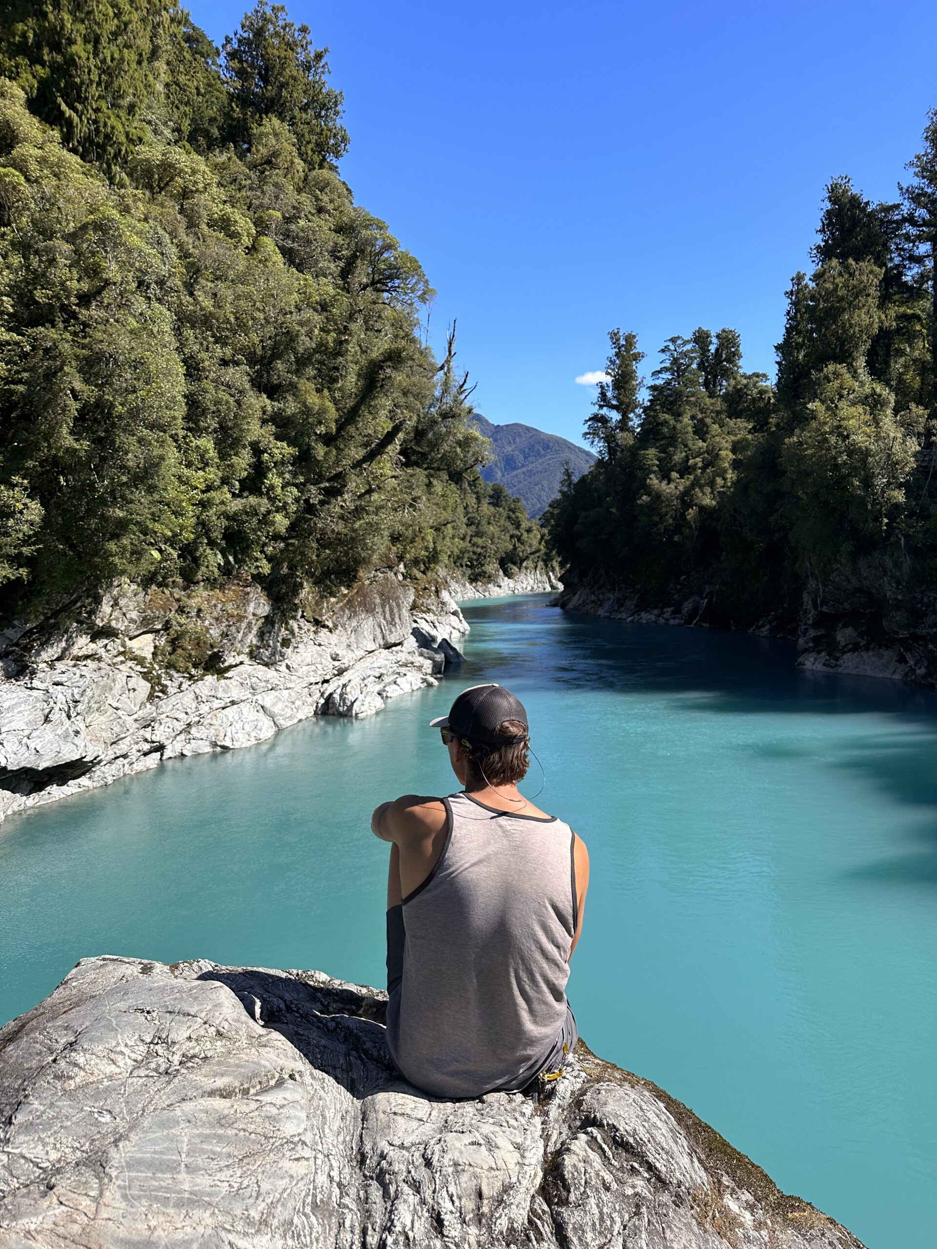 Sitting on a rock at Hokitika Gorge on the South Island of New Zealand