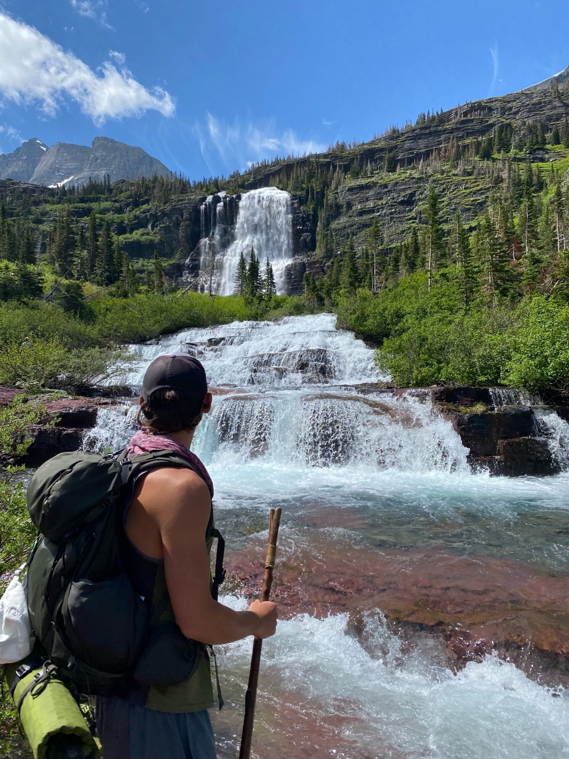 backpacker in front of waterfall in backcountry